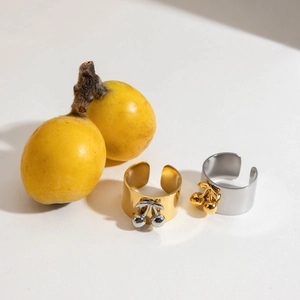 Detailed shot of gold and silver cherry charms on adjustable stainless steel rings