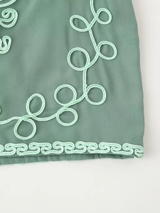 Détail de l'ensemble de plage vert avec broderies délicates et bord festonné