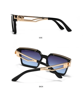 Detail view of square sunglasses with thick black frame and golden hollow metal temples