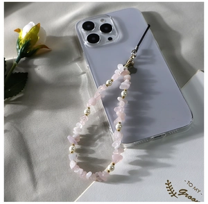 Détail de perles de cristal rose et perles sur un cordon de téléphone avec accents dorés