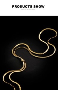 Detail of a golden snake chain necklace with textured metal surface and adjustable clasp