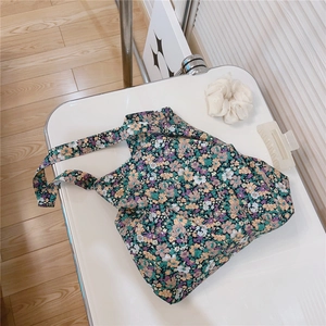Detailed overhead shot of floral canvas tote bag with purple and yellow flower patterns