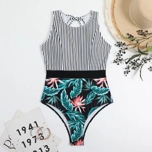 Flat lay of a striped halter neck one-piece swimsuit with tropical floral print and belt