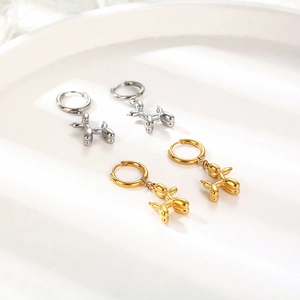 Polished silver and gold balloon dog hoop earrings displayed on a white tray