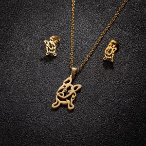 Macro detail of golden bulldog dog silhouette pendant necklace and matching stud earrings