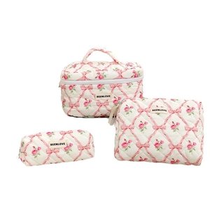 3-piece quilted makeup bag set with pink floral and bow patterns on a white background
