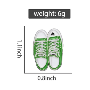 Detailed view of a green canvas shoe enamel pin with heart detail and 1.1x0.8 inch dimensions