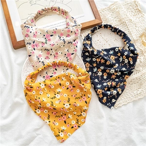 Detailed flat lay of beige, black and yellow floral print elastic triangle headbands