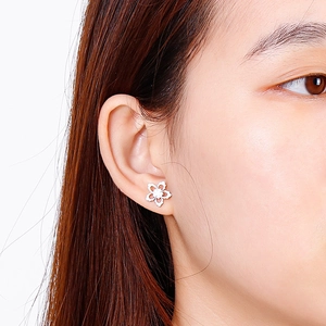 Close-up of silver hollow snowflake stud earring worn by model in a stylish metal set