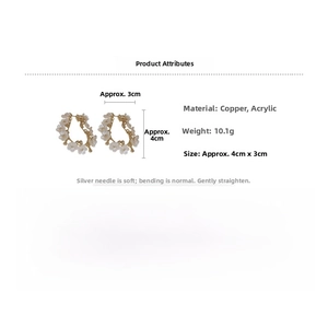 Détail d'une boucle d'oreille fleur avec pétales blancs et base en cuivre doré