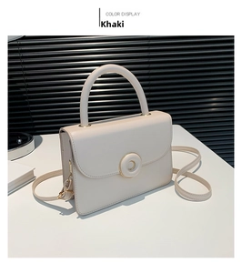 Detail of khaki leather handbag featuring elegant round gold metal hardware and flap closure