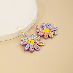 Détail macro de boucles d'oreilles marguerites tissées main avec texture bohème