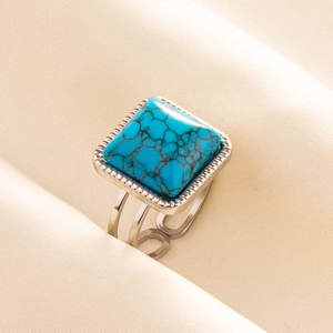 Macro detail of bohemian adjustable stainless steel ring with turquoise stone inlay