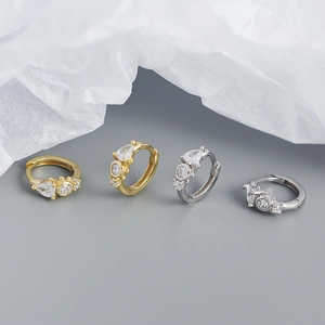 Detailed row of gold and silver hoop earrings with teardrop and round zircon stones