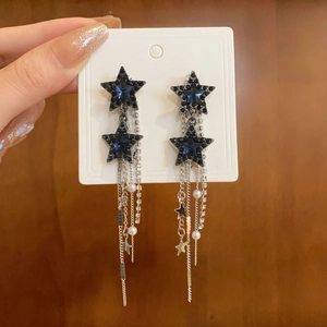 Detail of silver long tassel star earrings with sparkling crystals and imitation pearls