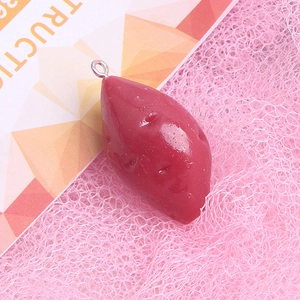 Realistic sweet potato resin pendant with metal loop on a soft pink mesh background