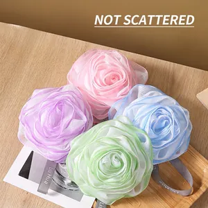 Four-color set of rose-shaped bath mesh sponges with hanging ropes on a wooden tray