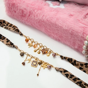 Détails d'une chaîne dorée avec ruban imprimé léopard et pendentifs décoratifs