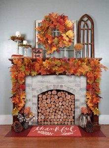 Close-up of autumn maple leaf garland and 'Hello Fall' wooden frame on a fireplace