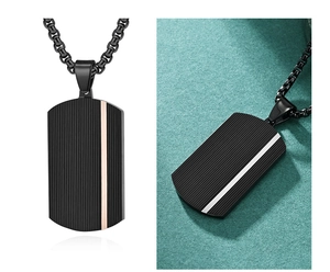 Close-up of black dog tag pendant with vertical texture and sleek gold stripe accent