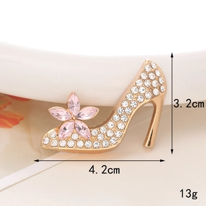 Macro view of gold high heel charm with clear rhinestones and pink crystal flower detail
