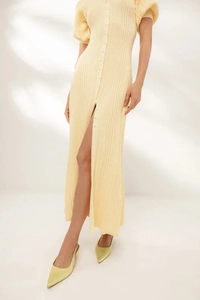 Close-up of ribbed knit texture on light yellow puff sleeve dress with buttons