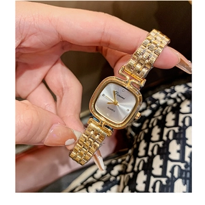 Macro detail of Dimini gold square watch with silver dial and diamond-set markers