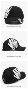 Detail of distressed black cotton baseball cap with Vibrate print and torn brim accents