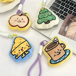 Detail of plush cartoon pendants with embroidery on a white desk with props