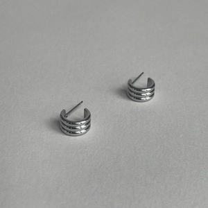 Macro shot of silver S925 earrings featuring a triple layered C-shaped circular design