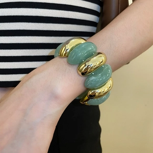 Detail of chunky acrylic marble effect links and gold metal segments on stretch bracelet