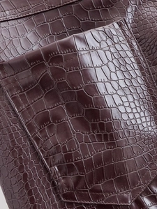 Close-up of deep brown crocodile embossed PU leather texture and stitching detail