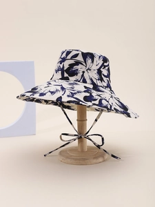Detail of wide brim sun hat with blue floral print and adjustable bow chin strap