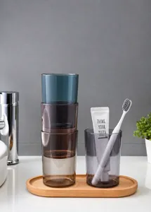 Stackable colorful transparent plastic tumblers in blue, purple, brown, and grey on a tray