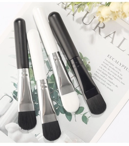 Detail of soft facial mask brush set with black and white bristles and silver ferrule