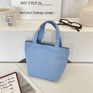 Close-up of a light blue canvas tote bag on a white step with lifestyle props