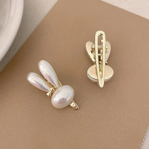 Elegant pearl finish rabbit hair clips with golden metal base on a vintage card