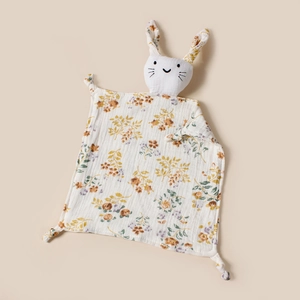 Détail d'un doudou en mousseline florale avec tête de lapin et tissu en coton doux