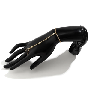 Detail view of a gold chain hand harness with faux pearls and sparkling rhinestones