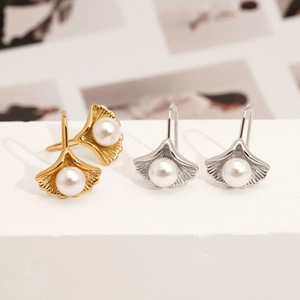 Elegant ginkgo leaf earrings in gold and silver with a central white pearl detail