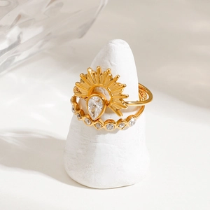 Gold plated stainless steel ring set featuring a sunburst teardrop zircon and pavé band