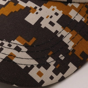 Macro view of digital camouflage pattern and reinforced stitching on a canvas baseball cap