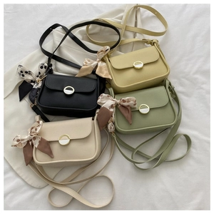 Close-up of four colors of faux leather bags featuring silk scarves and metal ring buckles