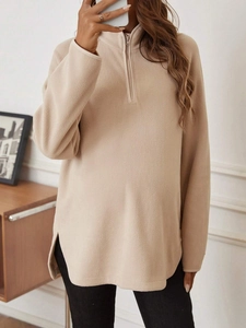 Detail of beige fleece maternity sweatshirt featuring half-zip collar and soft texture