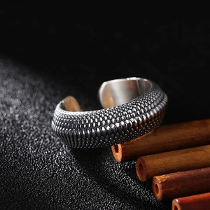 Detailed close-up of retro silver feather ring with scales texture and antique finish