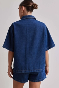 Detail der Rückansicht eines dunkelblauen Jeanshemds mit kurzen Ärmeln und Kontrastnähten