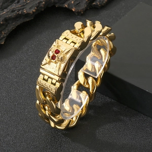 Close-up of gold skull link bracelet with red crystal eyes and polished cuban chain