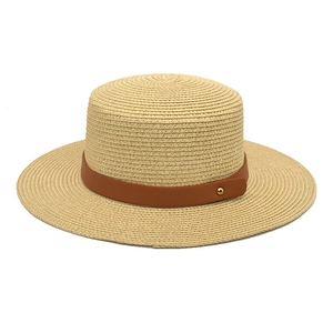 Detailed close-up of straw boater hat with dark brown leather band and gold stud accent
