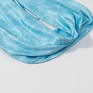Detail shot of light blue tie-dye fabric with smooth silk-like texture and soft drapes