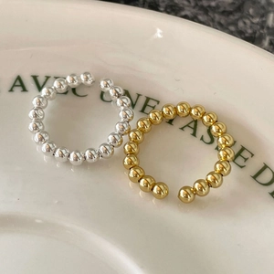 Minimalist 925 silver beaded open rings in gold and silver finish on a ceramic tray